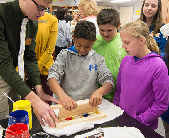 instructor assisting a student with screen printing